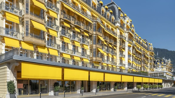 Quersicht an Längsfassade Hotel mit gelben Sonnenstoren